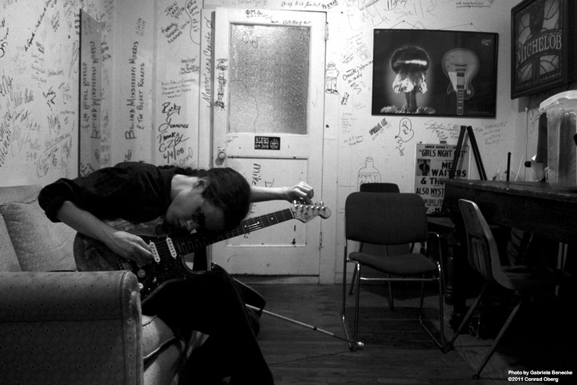 Conrad Oberg tuning his guitar backstage at ground zero blues club in clarksdale, mississippi
